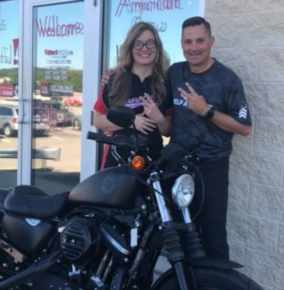 Chad Jordan and Shannon VIllers with Harley in front of Sport Clips